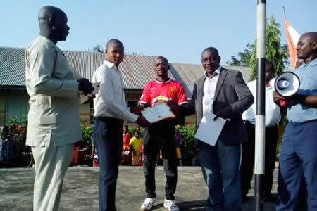 A recipient of the Scholarship Award from Evangelical Secondary School presented by the Director of Project Development of Tanimu Foundation.